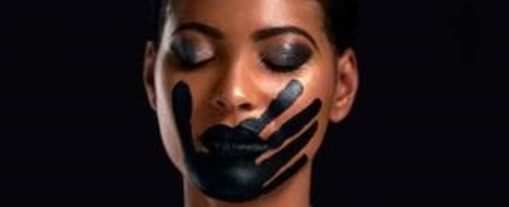 Black woman with black handprint over her mouth